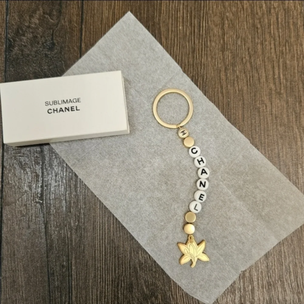 NIB CHANEL Sublimage Gold & White Beaded Keychain with Flower Charm